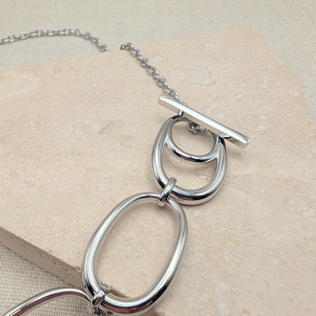 Little Nell Silver Pebble Link Statement Necklace on a minimalist background, detail of the T-bar