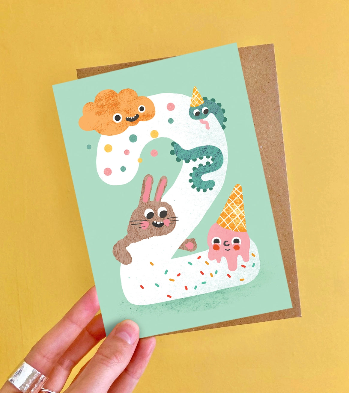 Children's Age 2 birthday card with cartoon characters on a light green background by Emily Nash. Made in the UK.