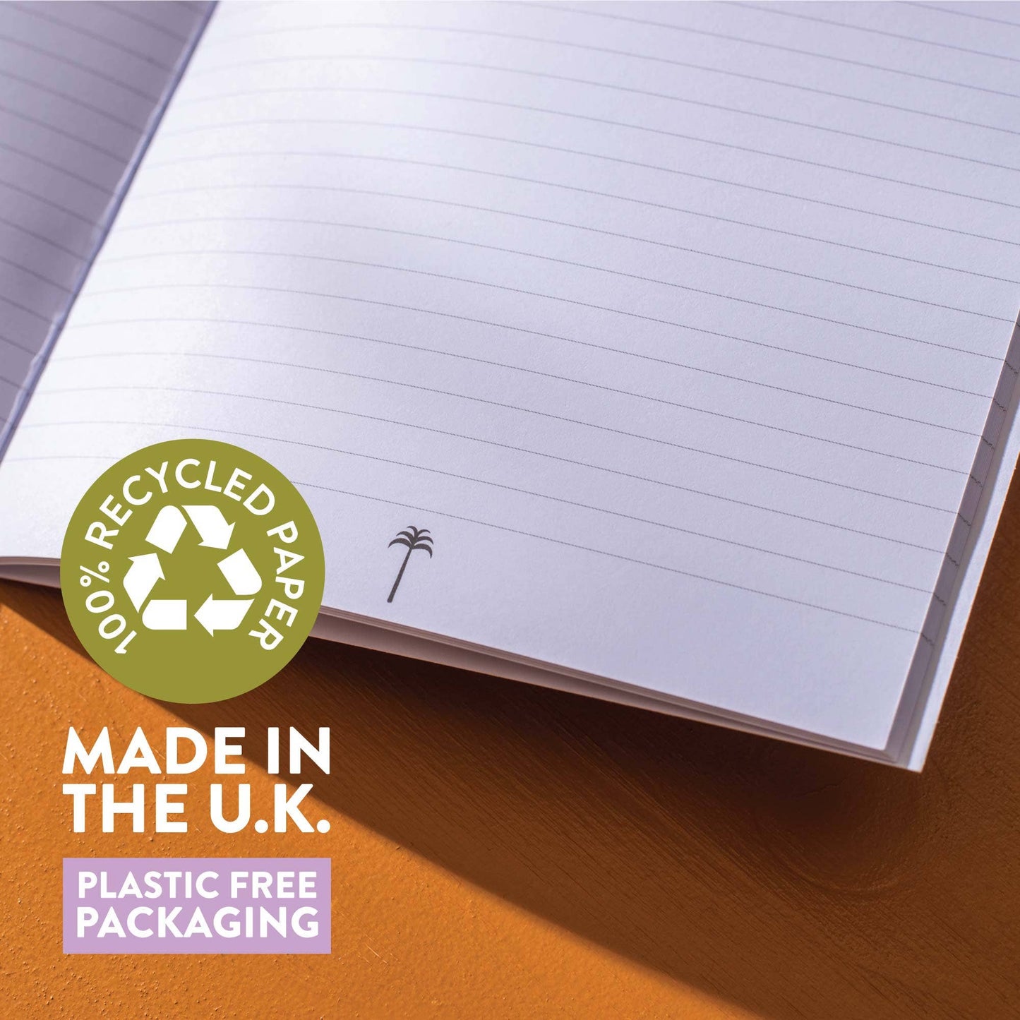 Open notebook with recycled paper label and 'Made in the U.K.' text on a wooden surface