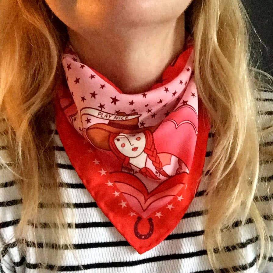 Eco silk twill pocket square with sassy cowgirl and white stallion, cacti, stars, boots, snakes, mountains, and horseshoe border in red and pink. Made from recycled polyester, designed by Su Owen.