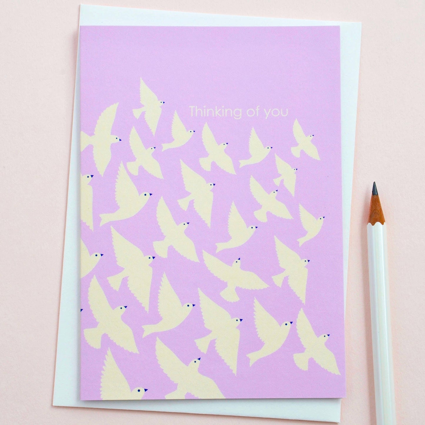 Illustrated ‘Thinking of You’ card with lilac birds in flight, printed on sustainable 350gsm matt card with cream envelope, blank inside.