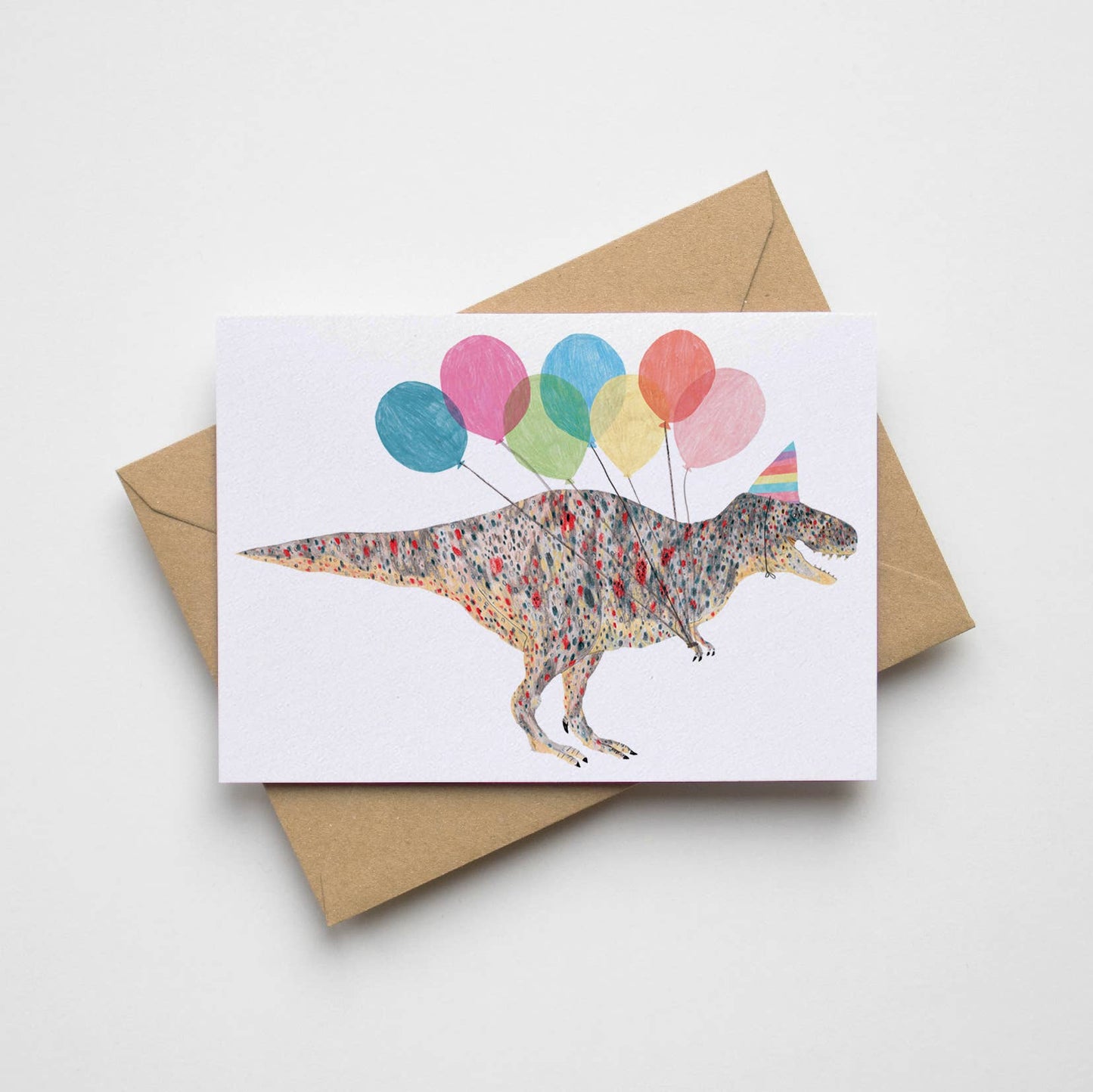 Playful T-Rex dinosaur birthday card with party balloons and a kraft envelope