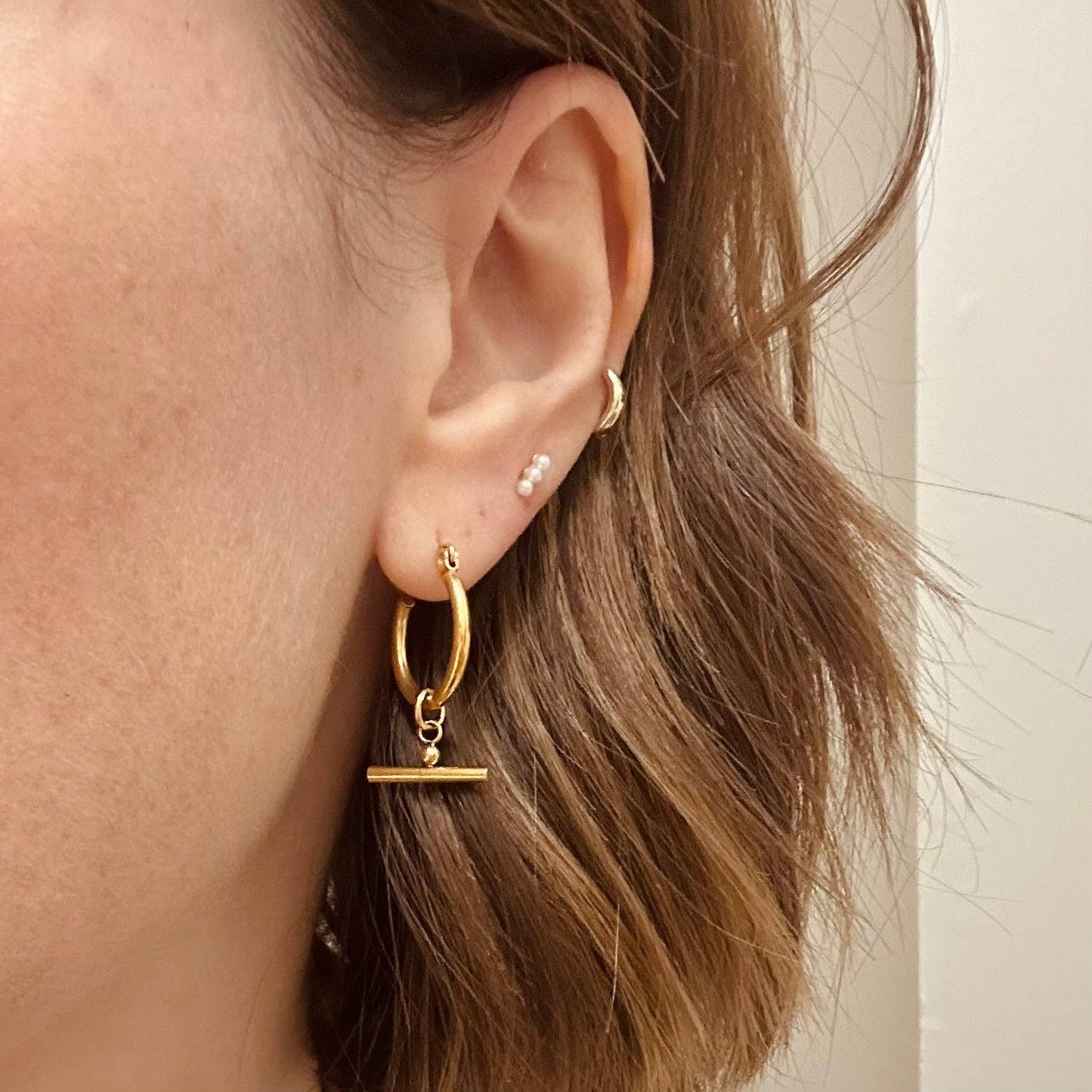 Pair of Little Nell lightweight gold bar hoops with removable charm, waterproof and hypoallergenic