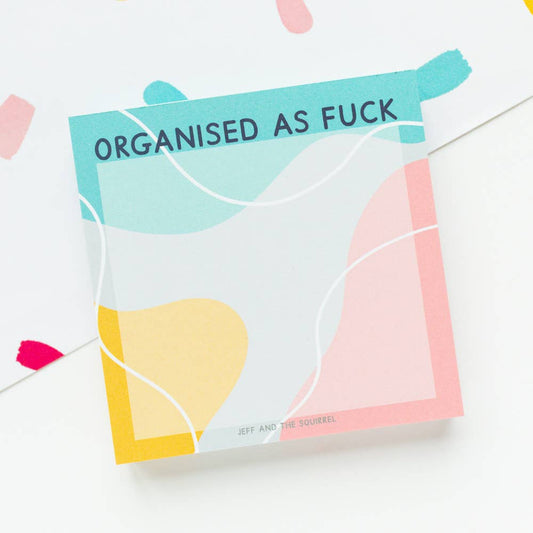 Close-up of the 'Organised As Fuck' memo pad with multiple sheets, highlighting recycled paper texture and eco-conscious vegetable ink print.