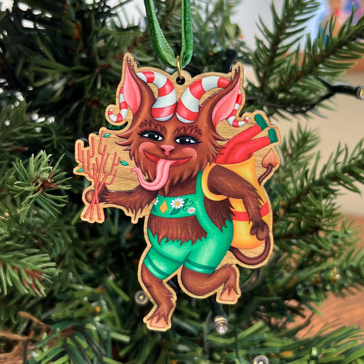 Krampus wooden Christmas tree decoration featuring Teddy & Kipling illustration, sustainably certified cherry wood, gold-plated ring, and dark green velvet ribbon