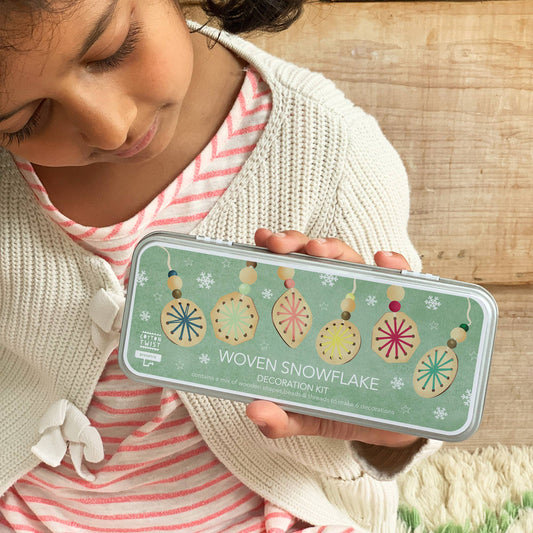 Contents of Woven Snowflake Decoration Kit: plywood bases, threads, beads, needle, tin.