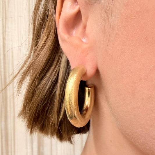 Close up of gold brushed finish on large hoop earrings