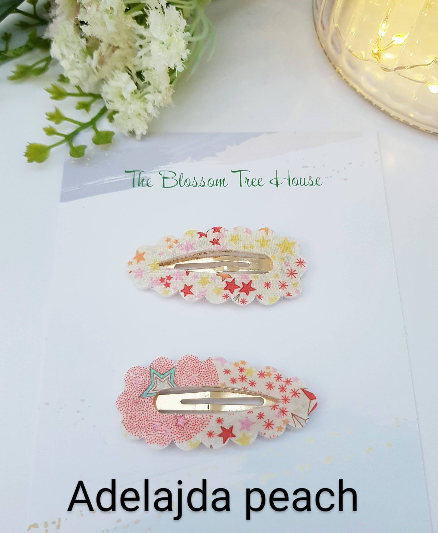 Two star hair clips on a white surface with 'The Blossom Tree House' branding.