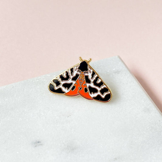 Tiger Moth Enamel Pin by Sarah Frances, 1 inch gold metal with hard enamel red and black garden moth design, pink rubber clutch back.