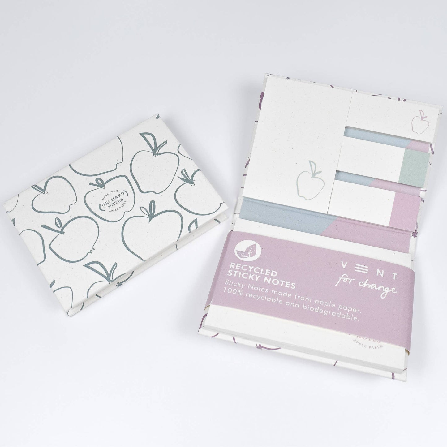 Two packs of recycled sticky notes with apple designs on a white background