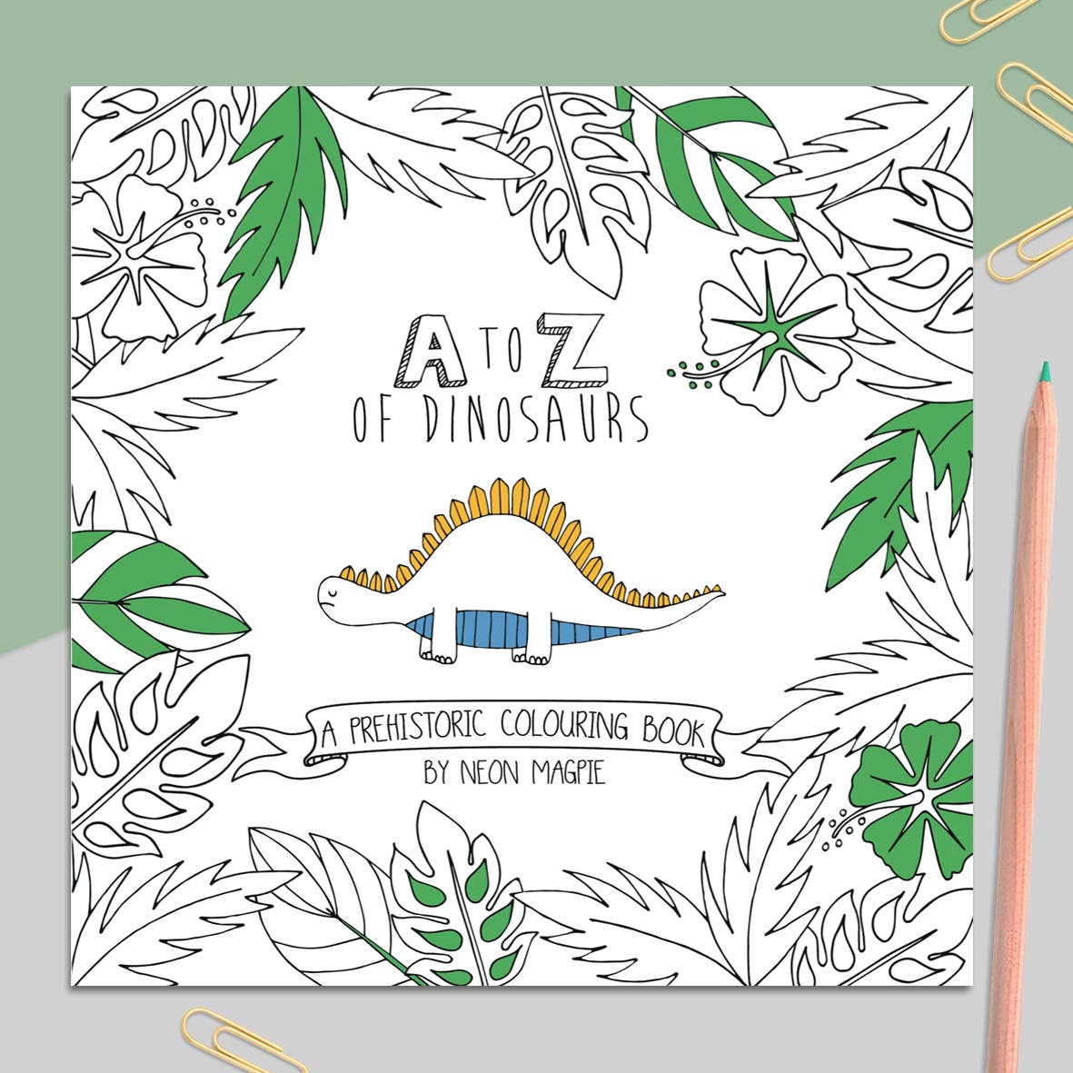 Dinosaur Colouring Book in use, open to a colouring page, pencils nearby.