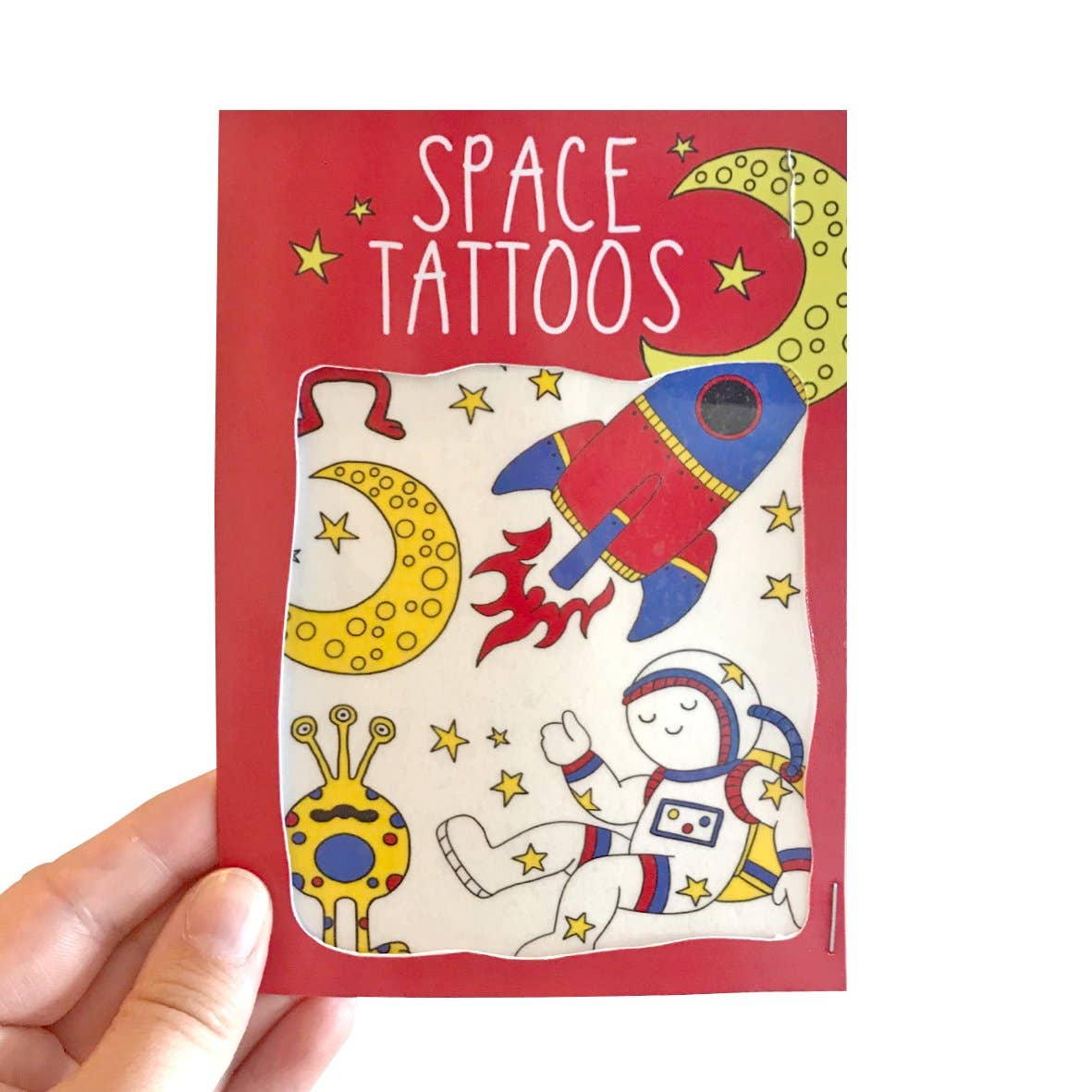 Close-up of Space Transfer Tattoos sheet featuring a rocket, aliens, planets, and stars, ready for application on clean skin