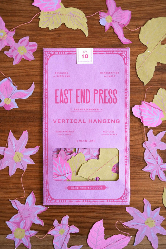 Close-up of East End Press Clematis vertical garland with intricate, colourful floral paper shapes.