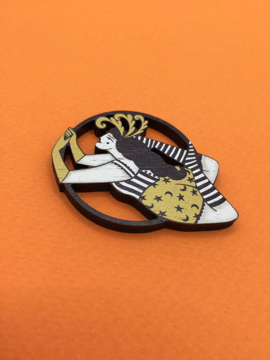 Close-up of Su Owen's Vintage Circus Aerialist wooden brooch, showing feather detail.