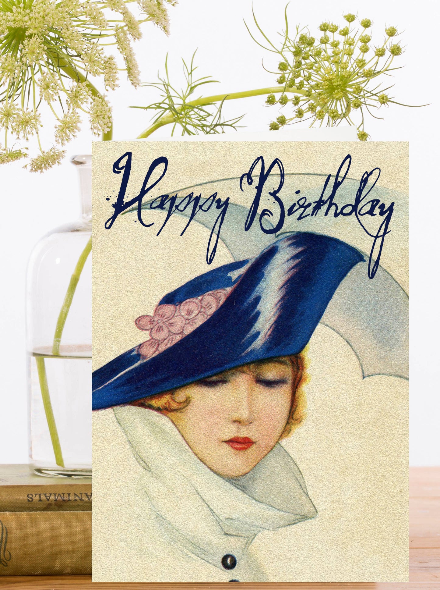 Vintage-style birthday card featuring a chic lady in a blue hat and coat from the 1920s, with a sustainable ivory envelope.