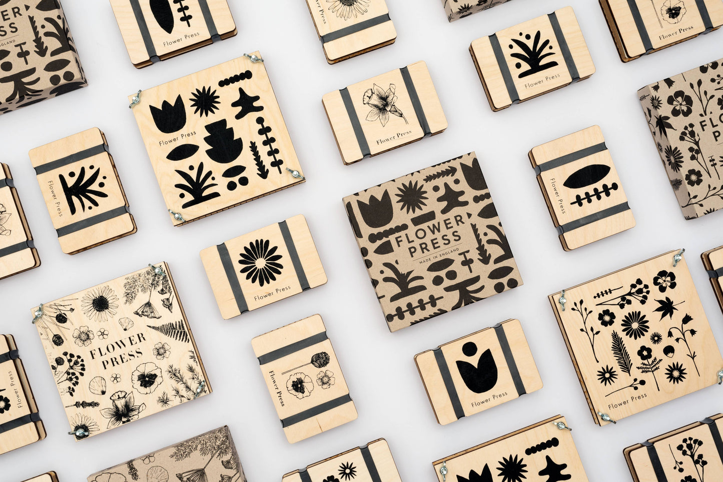 A selection of different flower presses made by Studio Wald. Black and white images of flowers on maple veneered sustainably sourced wood. Made in the UK.