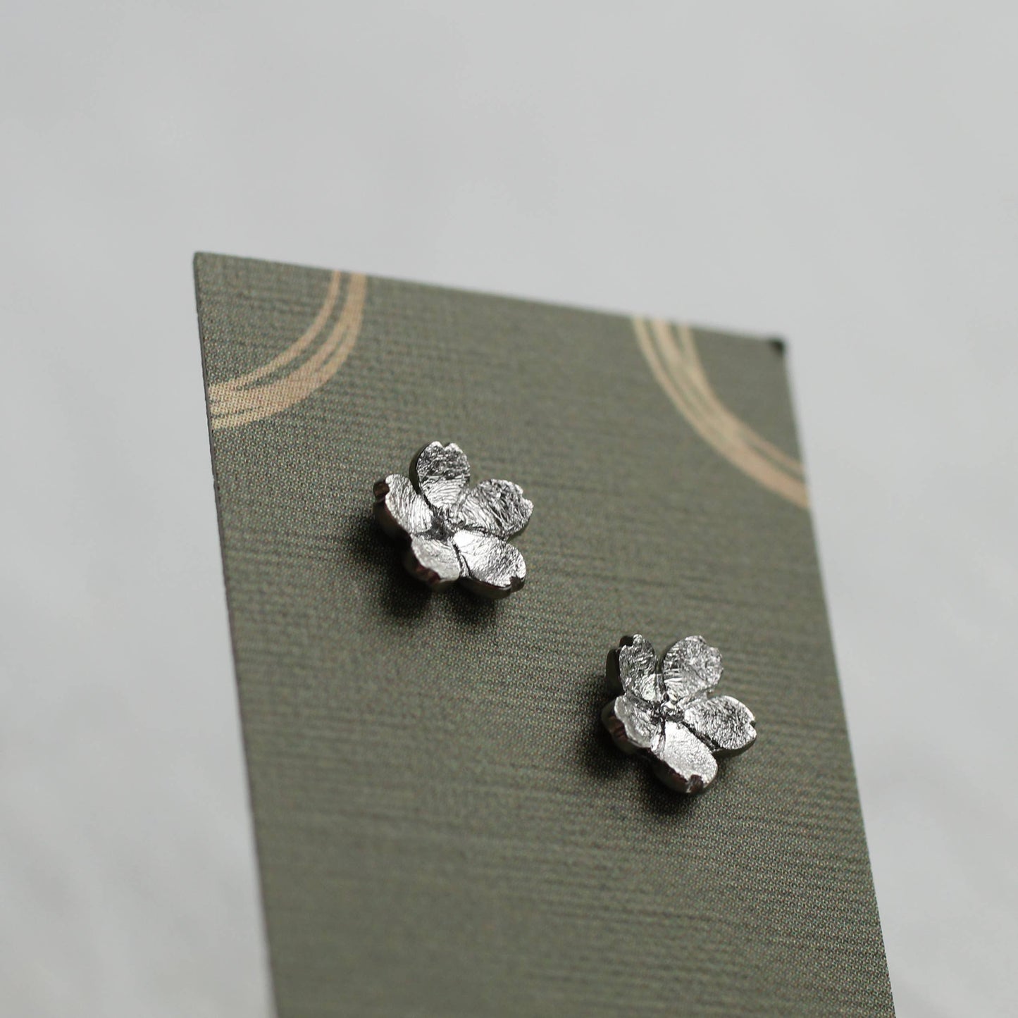 These sweet and dainty stud earrings feature a pair of tiny forget me not flowers, made from Sterling Silver with a subtle brushed texture. The earrings measure 9mm in diameter. These stud earrings come mounted on a linen presentation card.