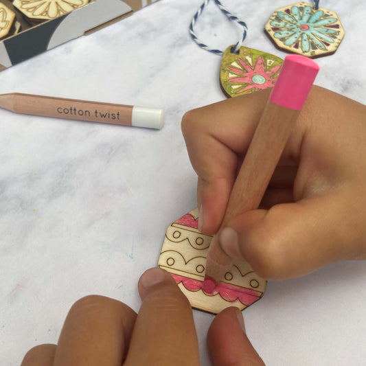 Child painting a wooden Christmas decoration from the kit