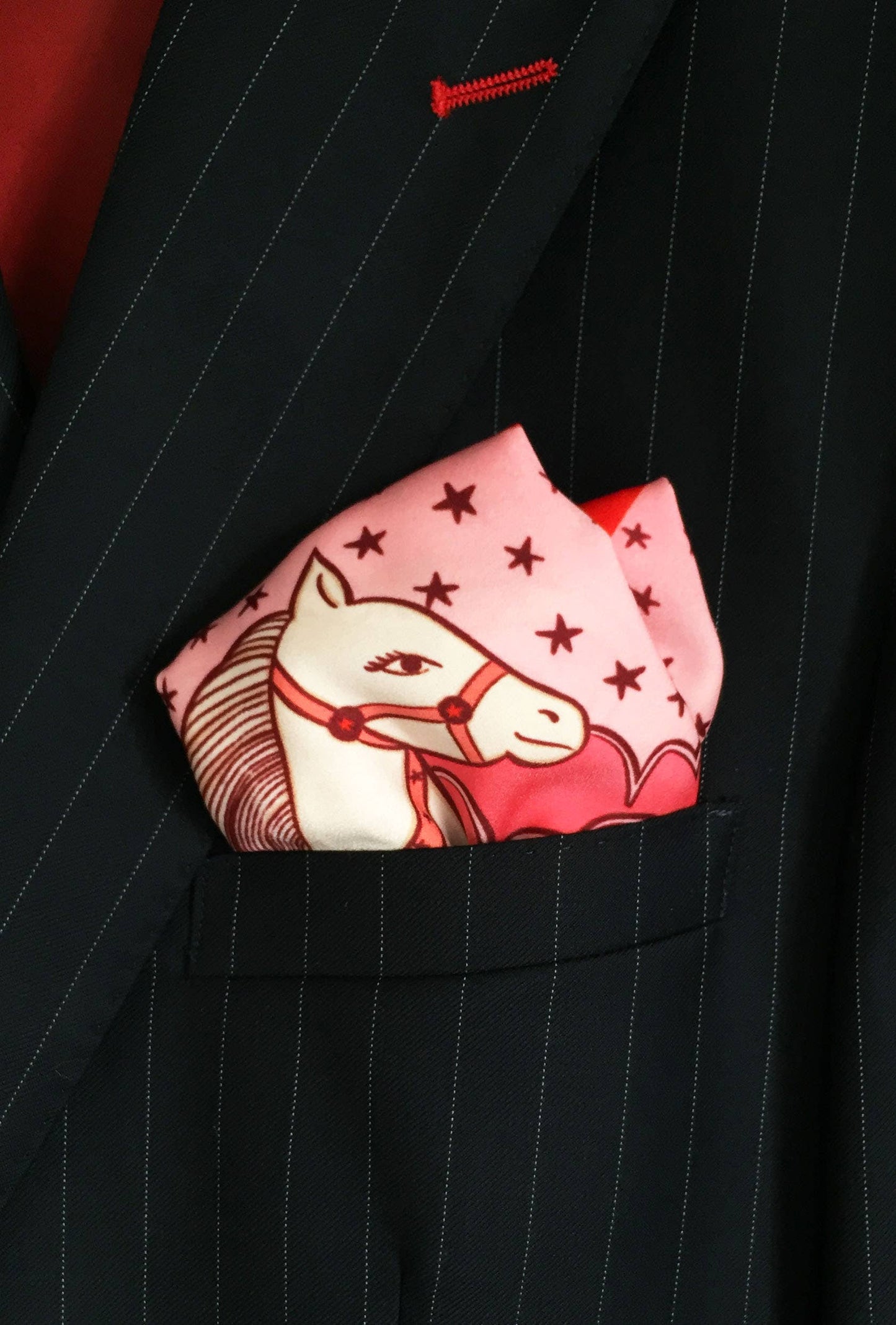 Eco silk twill pocket square with sassy cowgirl and white stallion, cacti, stars, boots, snakes, mountains, and horseshoe border in red and pink. Made from recycled polyester, designed by Su Owen.