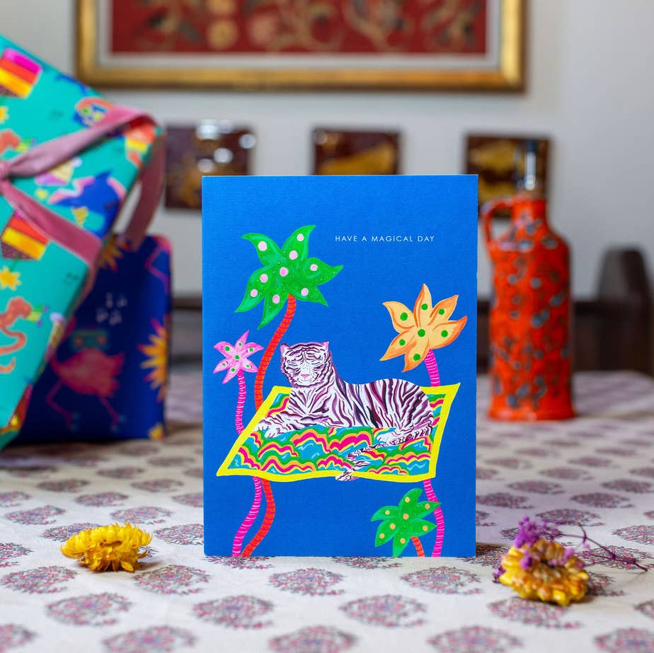 Hand-illustrated magical tiger on a magic carpet among palm trees, 5x7” birthday card, recycled kraft envelope, UK made, sustainable and mystical design.