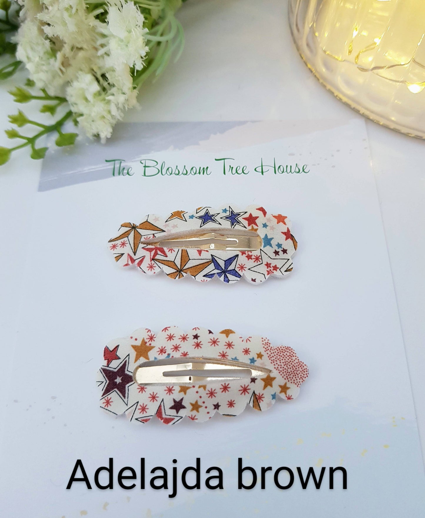 Two star hair clips on a white surface with 'The Blossom Tree House' branding.