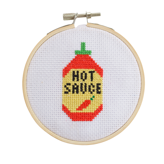 Completed hot sauce bottle cross stitch design in kitchen
