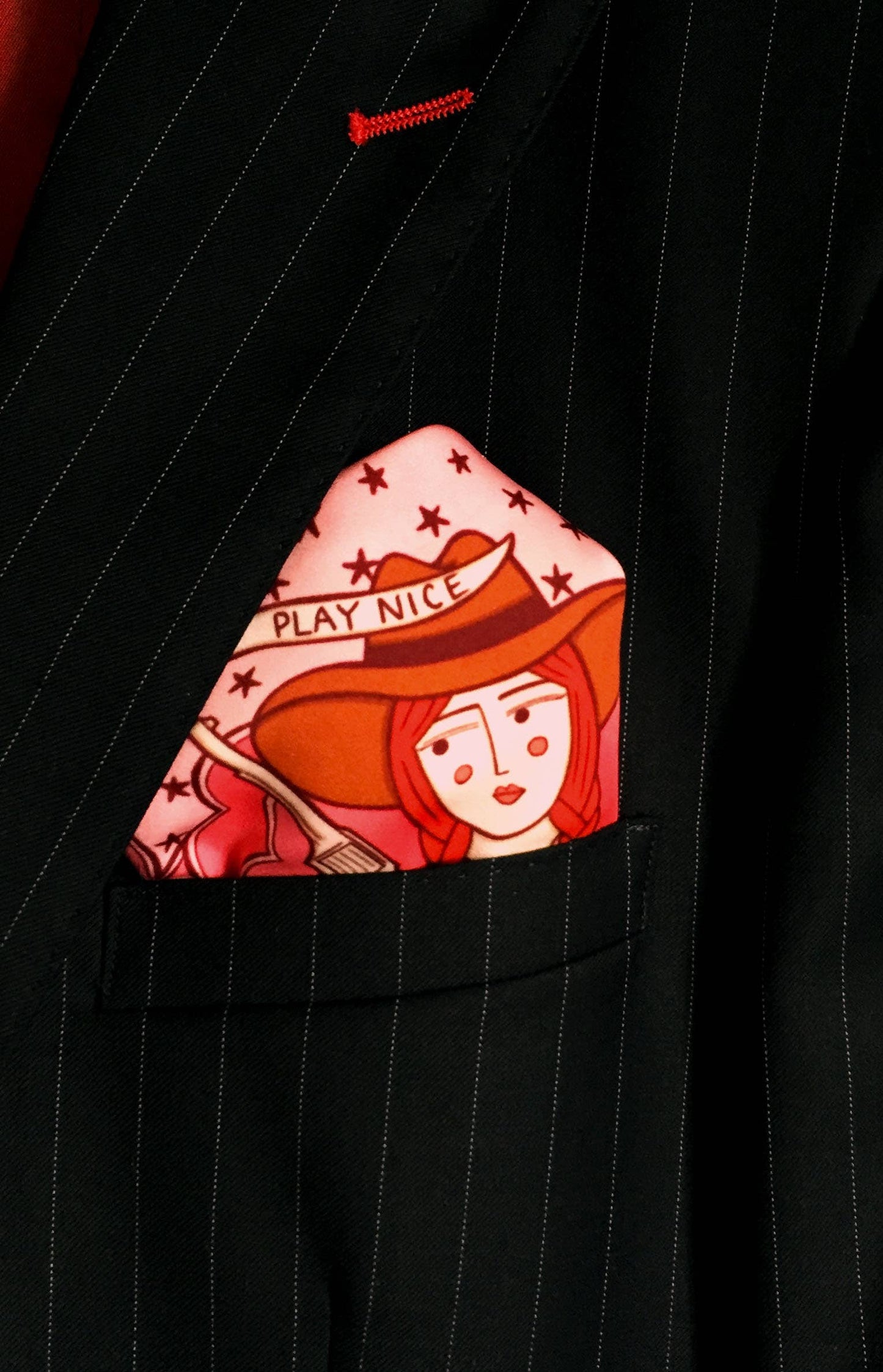 Eco silk twill pocket square with sassy cowgirl and white stallion, cacti, stars, boots, snakes, mountains, and horseshoe border in red and pink. Made from recycled polyester, designed by Su Owen.