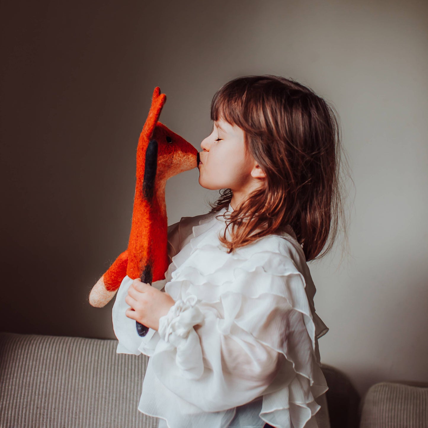 Child's hand holding Fraser Fox hand puppet, ready for imaginative play