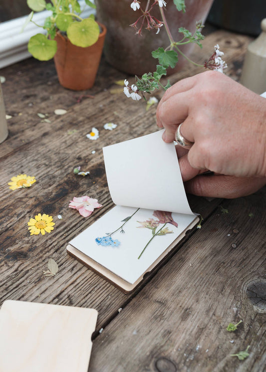 Pocket-sized wooden flower press with vintage botanical print