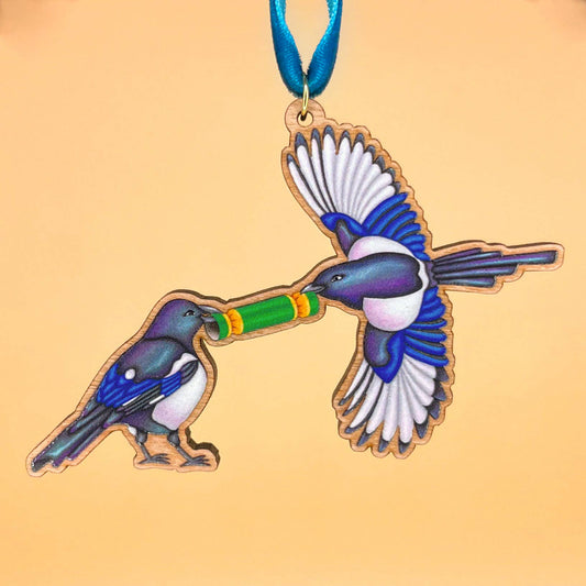 Magpie wooden Christmas tree decoration featuring Teddy & Kipling illustration, sustainably certified cherry wood, gold-plated ring, and dark teal velvet ribbon