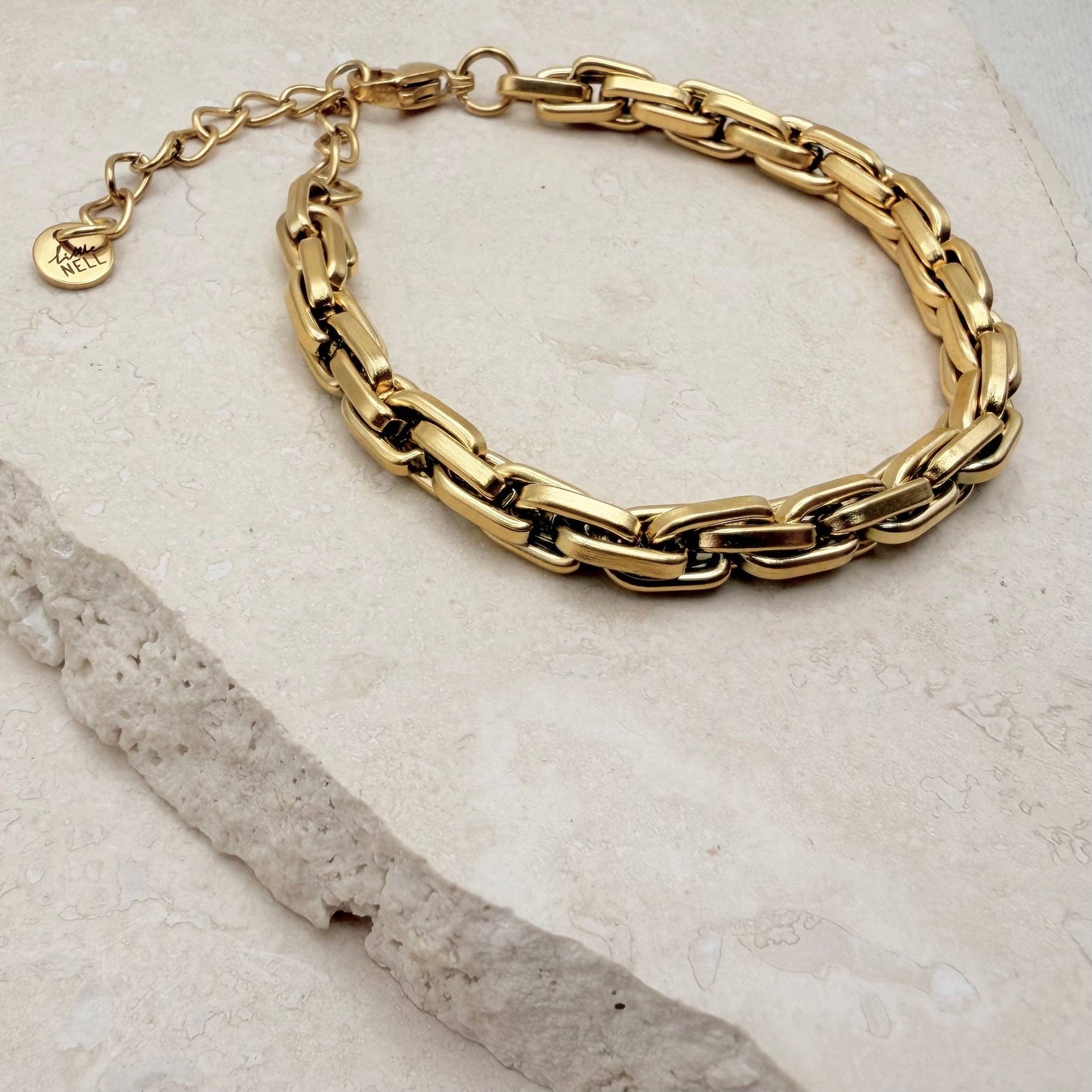 Stacked gold box chain bracelet on wrist