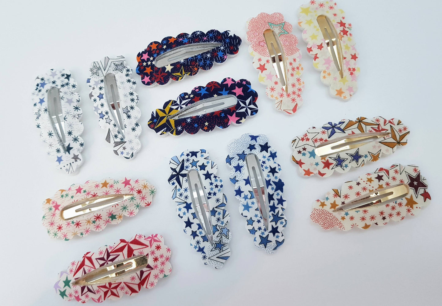 Collection of colorful floral and star-patterned hair clips on a white background