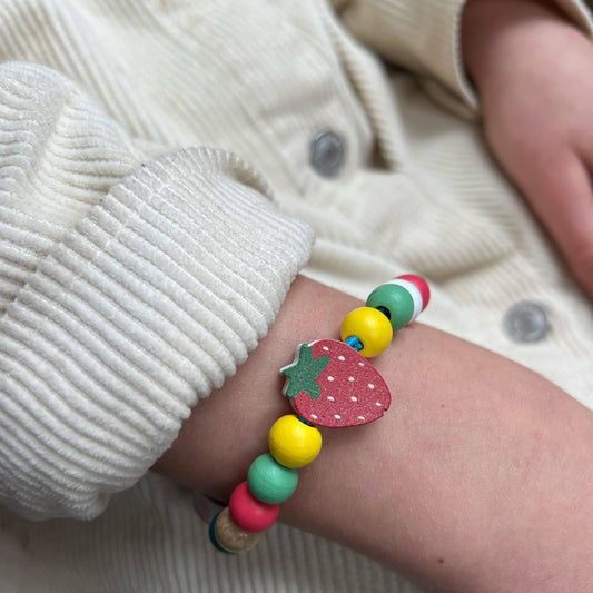 Child's Hands Crafting Strawberry Bracelet