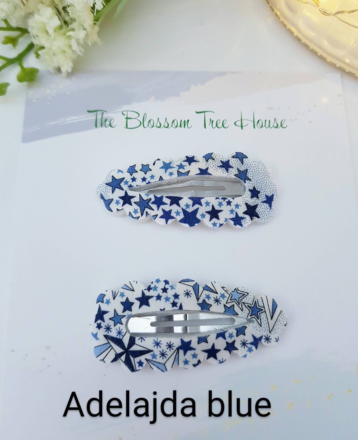 Two blue and white star-patterned hair clips on a white background with 'The Blossom Tree House' branding.
