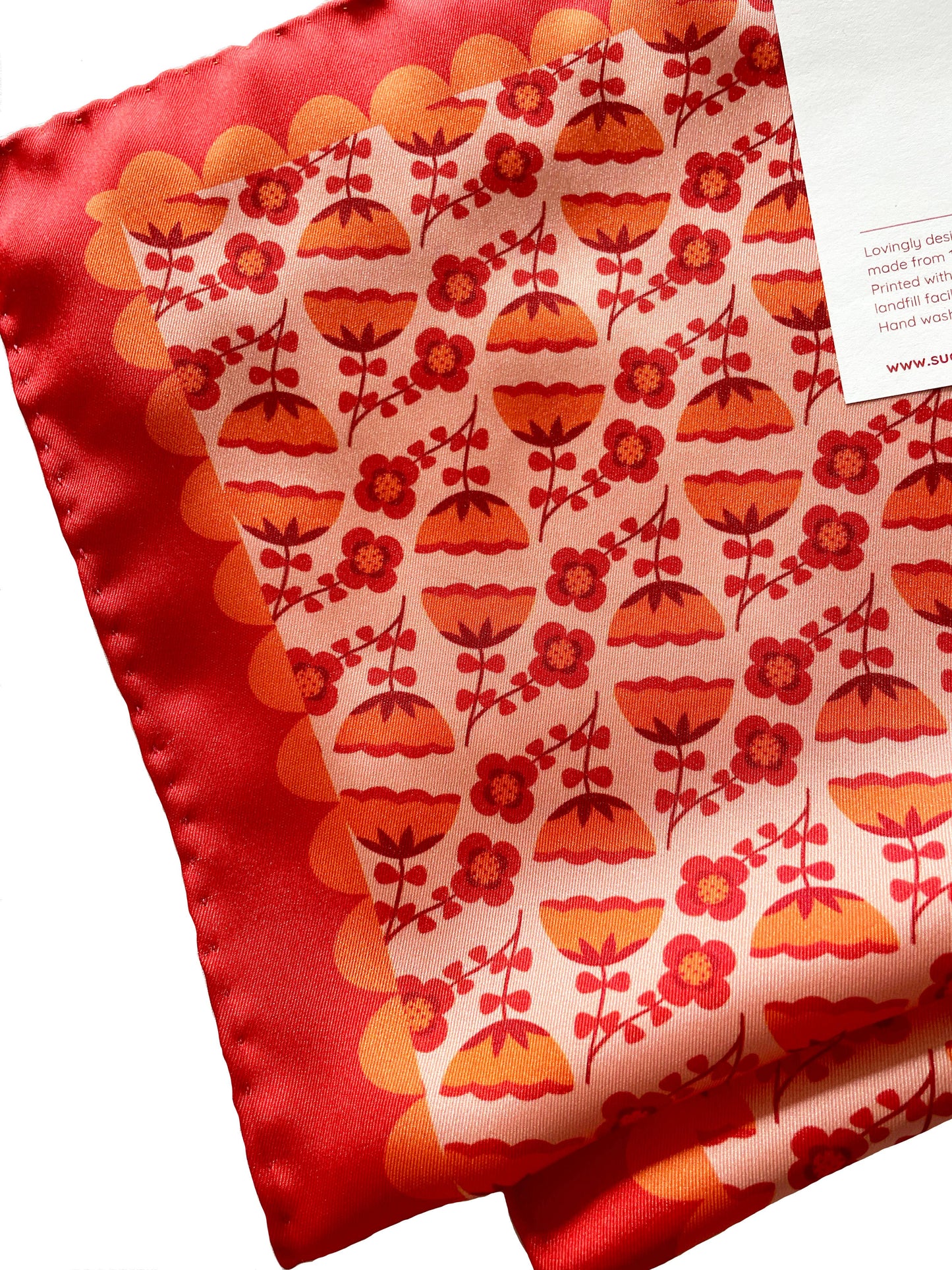 Eco silk twill pocket square with orange folk flower pattern and scalloped border, cottagecore style. Made from recycled polyester and designed by Su Owen.