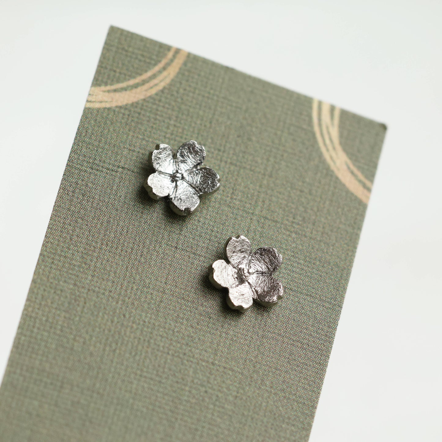 These sweet and dainty stud earrings feature a pair of tiny forget me not flowers, made from Sterling Silver with a subtle brushed texture. The earrings measure 9mm in diameter. These stud earrings come mounted on a linen presentation card.