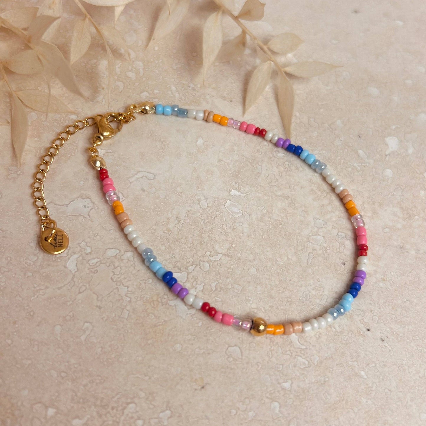 Close-up of a multicolour beaded 18k gold plated bracelet on a wrist, showcasing its delicate design and vibrant beads. Perfect for stacking.