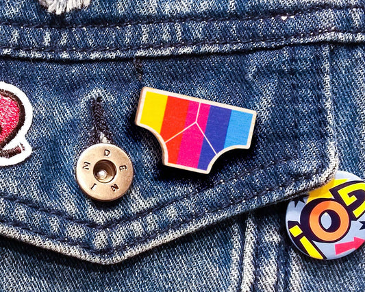 Close-up of Rainbow Power Wooden Pin Badge showing sustainable beech plywood texture