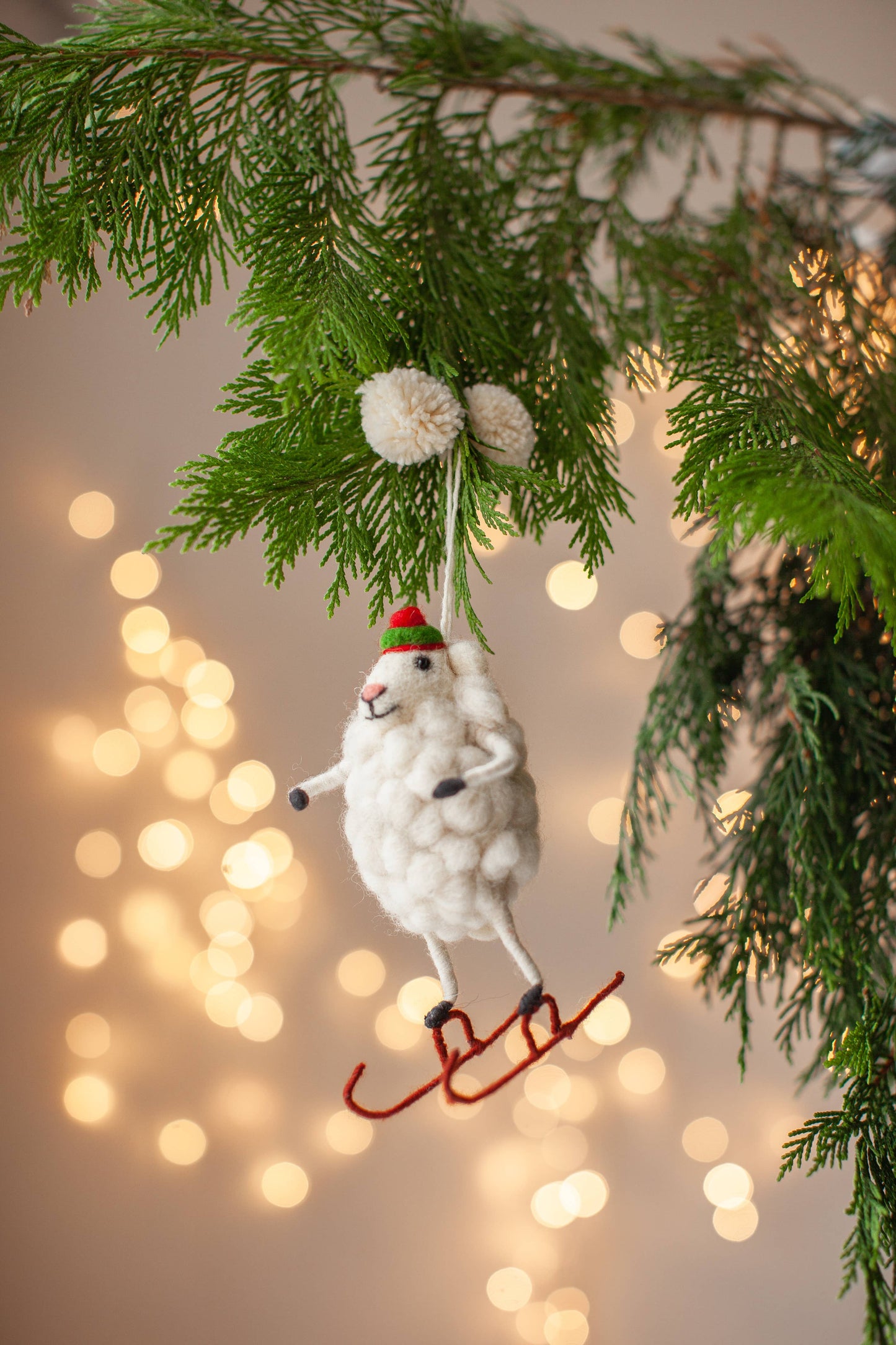 Handmade Skater Sheep Christmas decoration with detailed embroidery, fine needle felting, wooly hat, and pom pom hanger for hanging on Christmas tree.