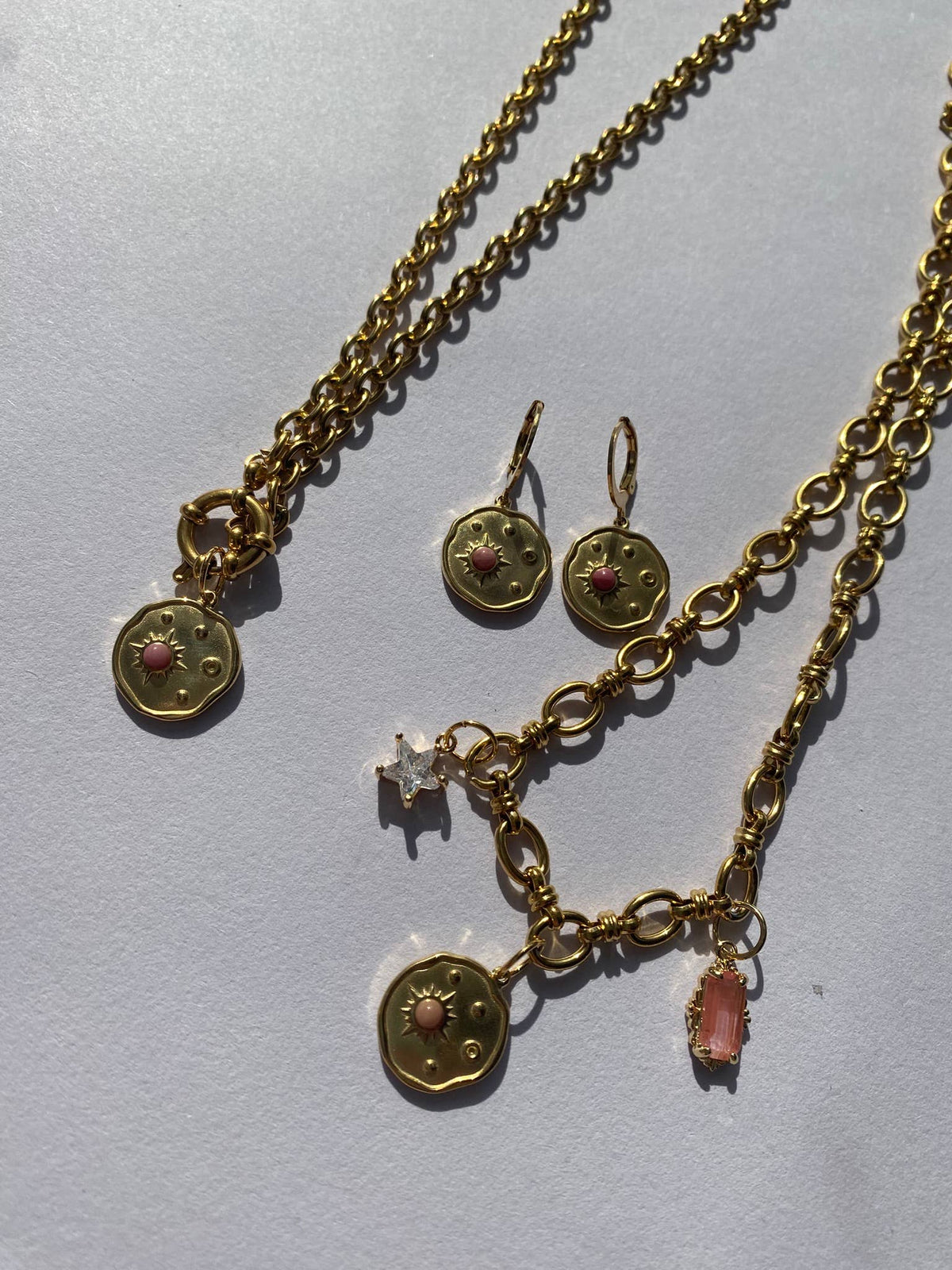 Close-up of celestial disk charm with pink stone and cubic zirconia star