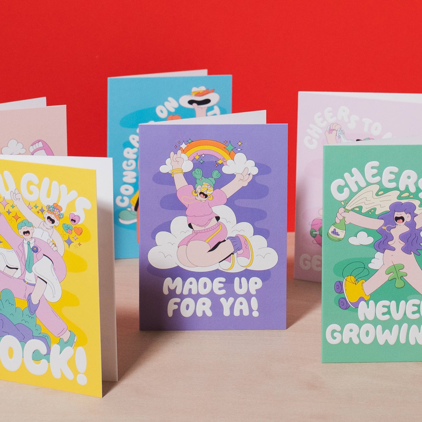 Colorful greeting cards with cartoon designs on a red background