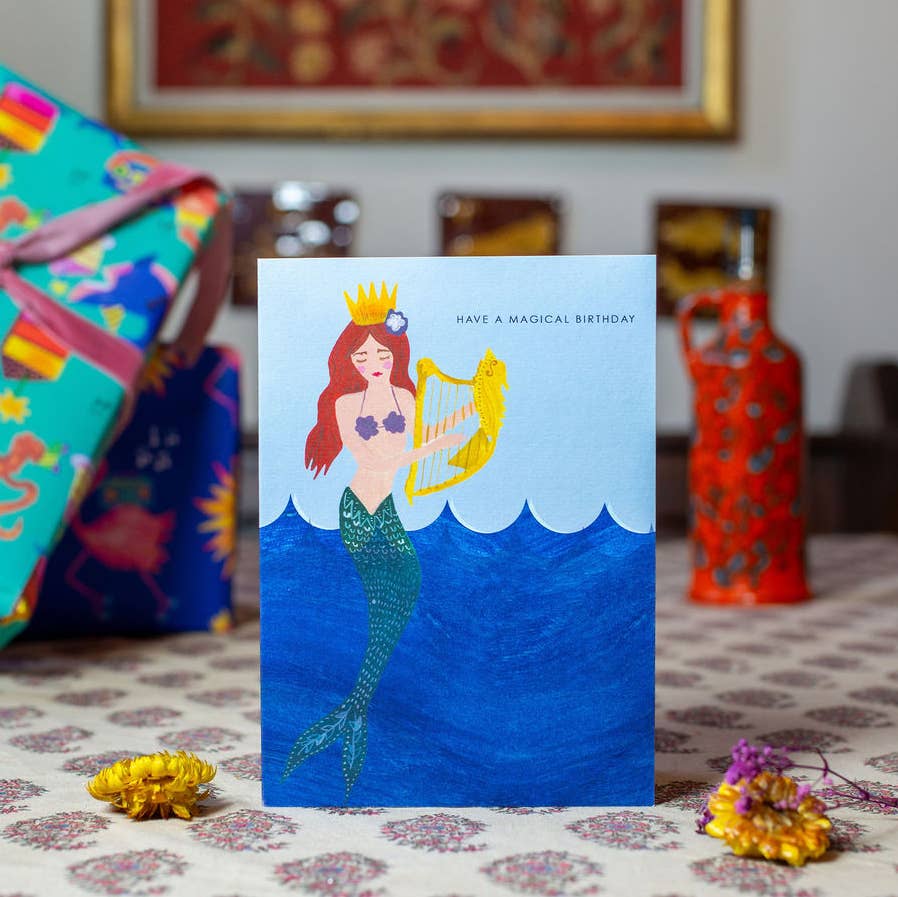 Hand-illustrated “Magical Mermaid” birthday card featuring a joyous colourful mermaid, 5x7", recycled kraft envelope, UK made, sustainable design.