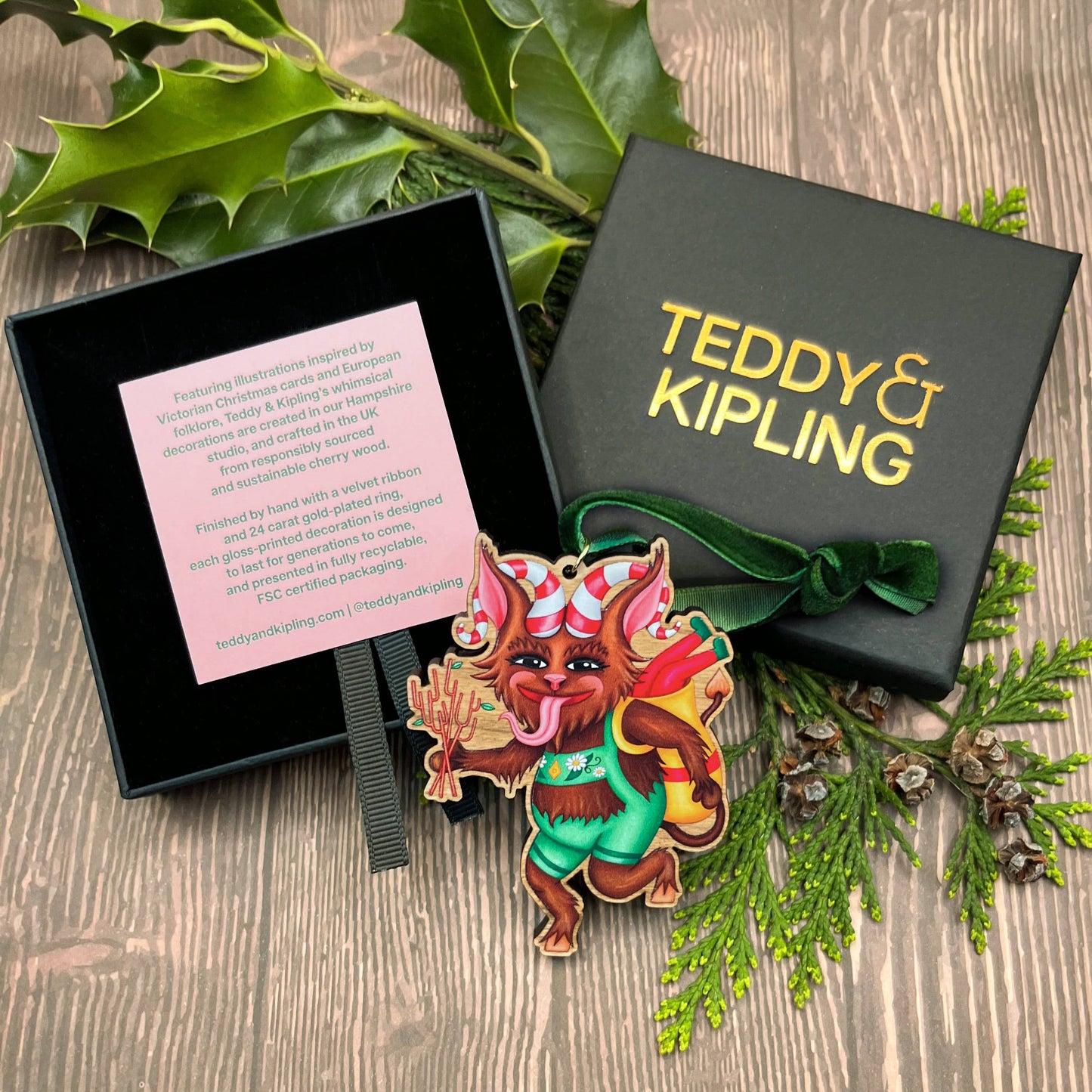 Krampus wooden Christmas tree decoration featuring Teddy & Kipling illustration, sustainably certified cherry wood, gold-plated ring, and dark green velvet ribbon