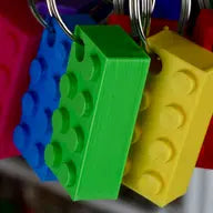Close-up view of a Made Happy biodegradable brick keyring in vibrant red