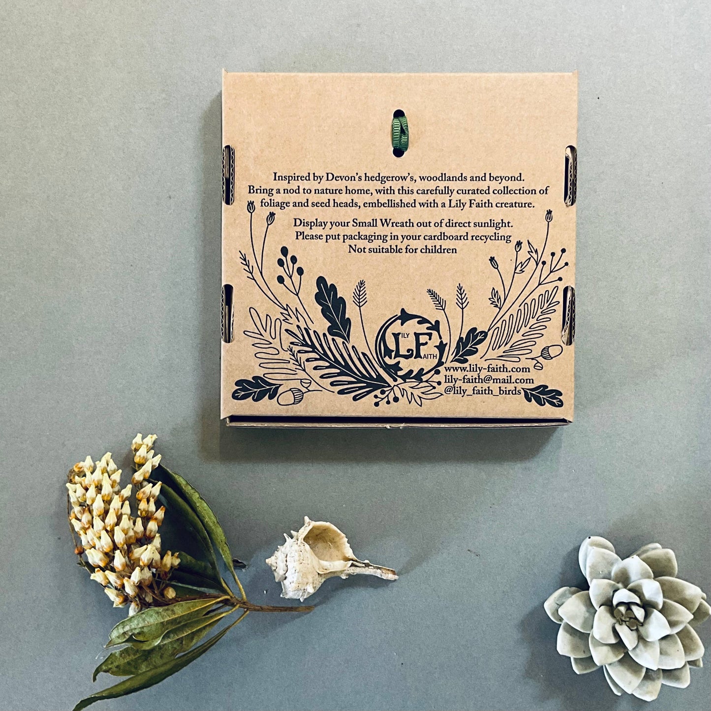 Back of the stag wreath's recyclable packaging box with illustrations and warnings