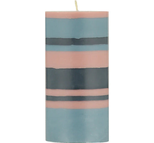 Close-up of a vibrant eco striped pillar candle with Rose Pink, Indigo Blue, and Pompadour colours.