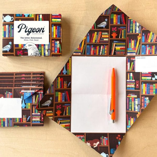 Bookstore Pigeon letter set, inspired by origami, featuring brown bookshelves filled with colourful books, a white teapot, and a charming pigeon illustration. A unique letter and envelope combination for thoughtful communication.