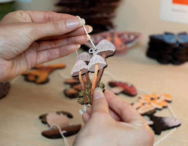 Hand designed Mushrooms of the British Isles garland, perfect for decorating your home or workspace. Perfect for nature lovers or toadstool enthusiasts. Made from sustainably sourced maple wood.
Made in Dapple & Dot's New Forest studio, from the illustration, to the laser cutting, to the printing to the packing.
EACH PRODUCT INCLUDES: 1 x pop out wooden sheet, 2 metres of cotton twine, 1 x labelled kraft envelope as packaging.
