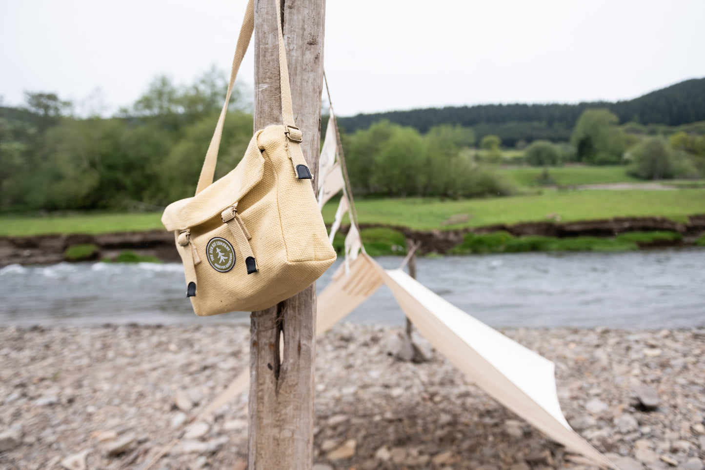 Pirate Den Kit including yellow cotton haversack, cotton calico tarpaulin, waterproof groundsheet, handmade wooden mallet, jute rope, steel tent pegs, pirate eye patch, and Jolly Roger bunting.