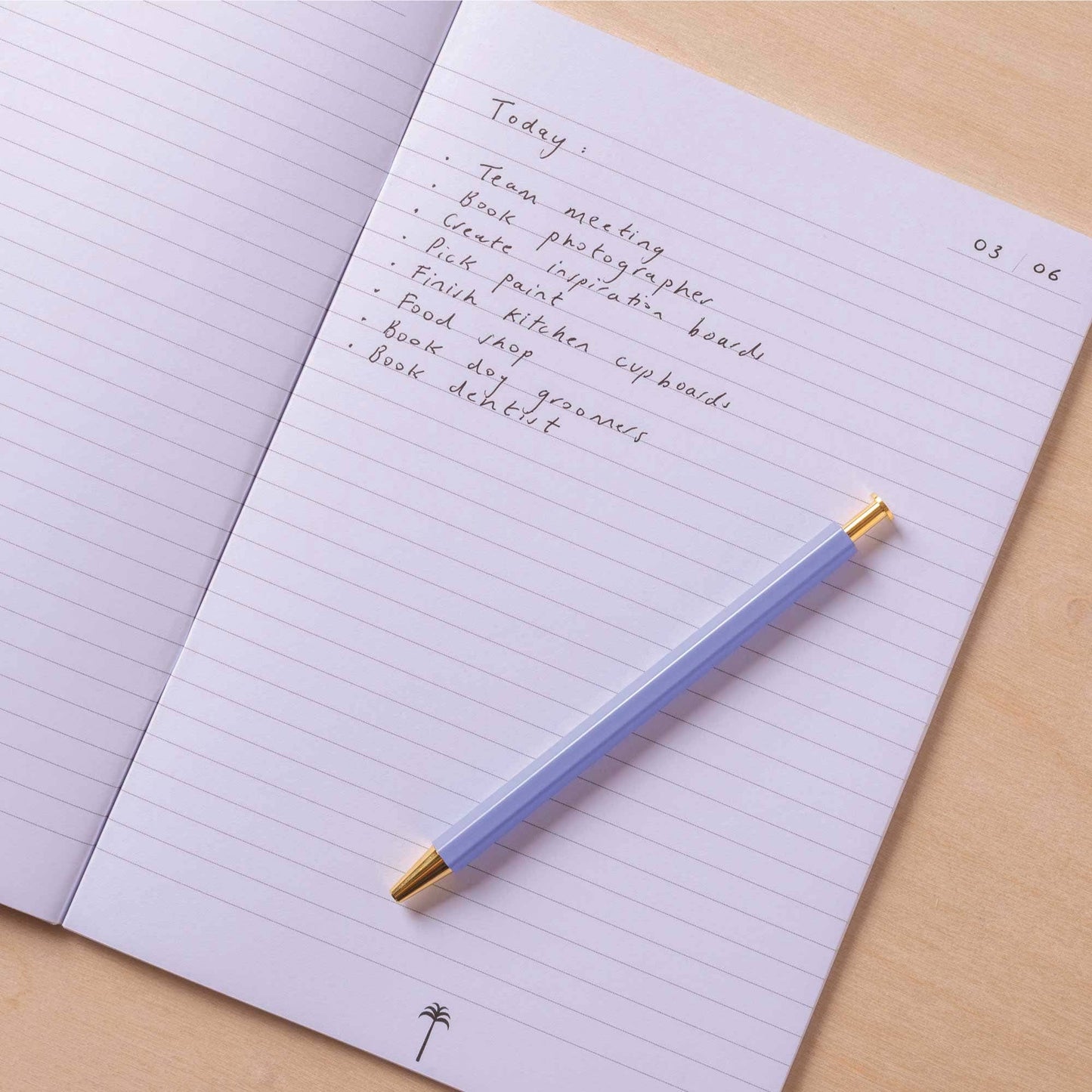 Notebook with handwritten text and a pen on a wooden surface